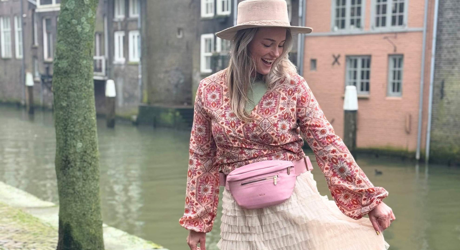 roze buiktasje op dame buiten langs de gracht