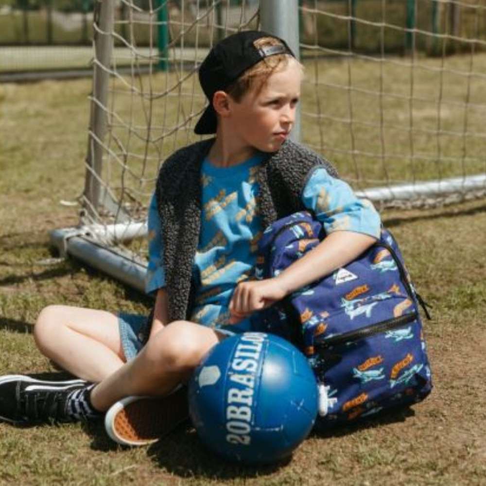 Stoere kinderrugzak met voetbalvliegtuigen, oranje 'Hattrick' en 'Legend' banners en vliegtuig-sleutelhanger met licht en geluid sfeer