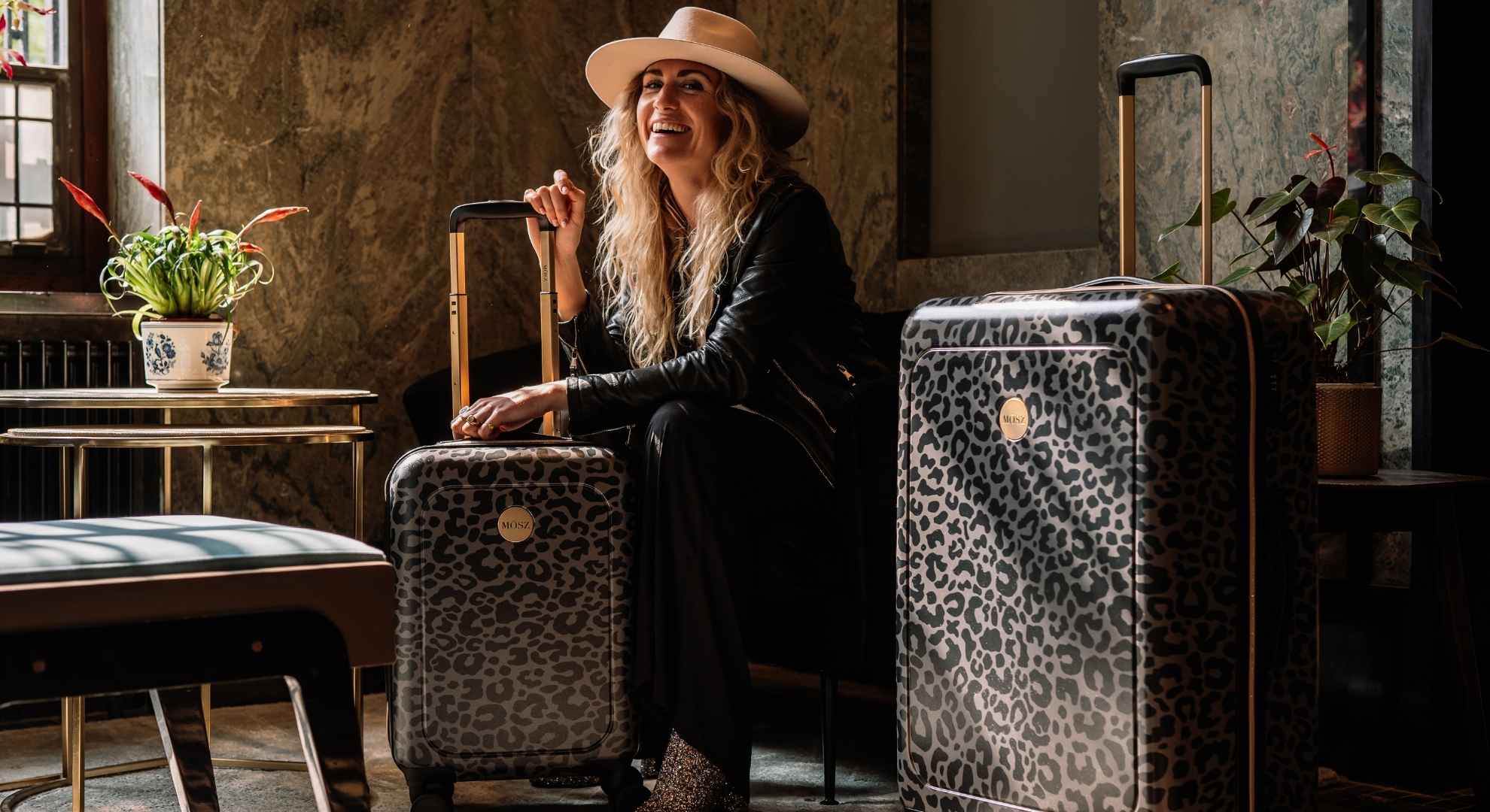 koffers voor dames in zwarte panterprint met dame in hotel