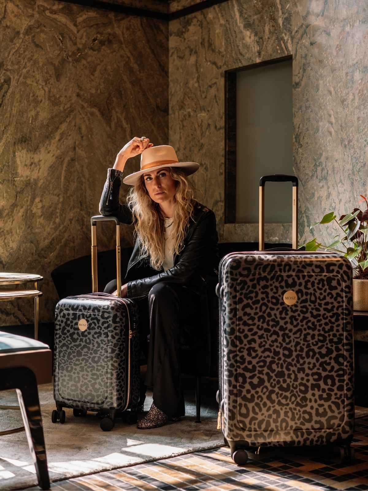 koffers voor dames in zwarte panterprint met dame in hotel