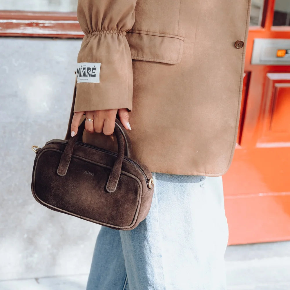 Suede handtas dames donkerbruin MŌSZ Jenny in de hand