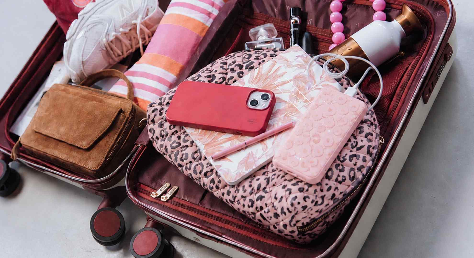 Roze powerbank in een handbagage koffer