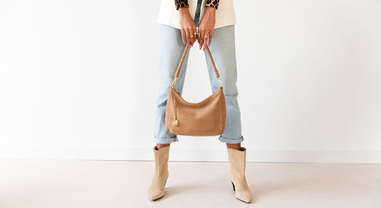 Suede tas in beige in handen van model