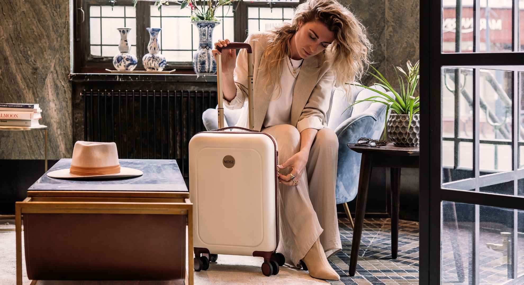 Vrouw met stijlvolle merk koffer, klaar voor een avontuurlijke reis