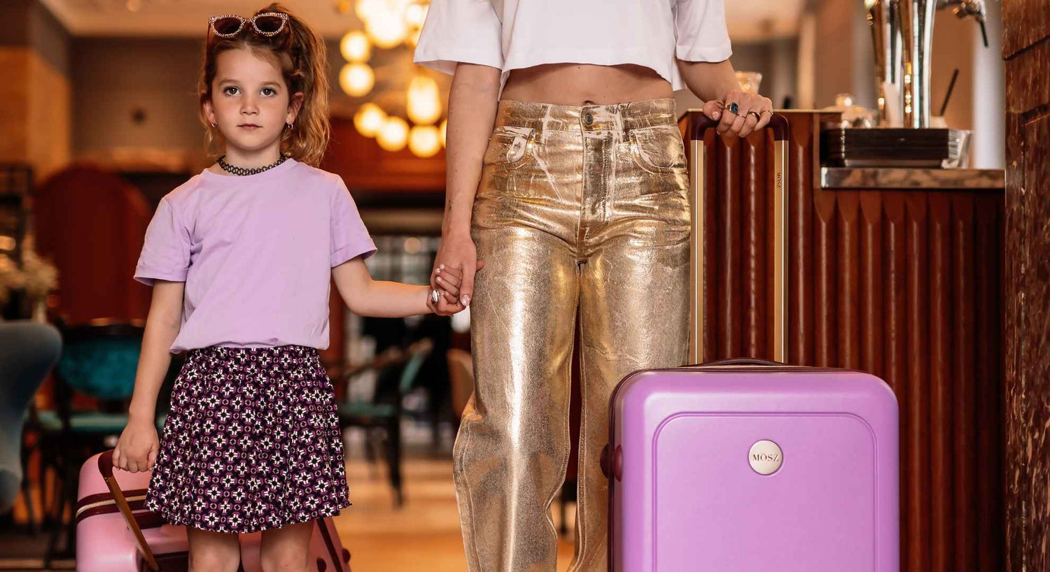 Moeder en dochter met stijlvolle paarse MŌSZ koffers – klaar voor een kerstvakantie vol avontuur en gezelligheid